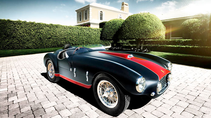 A TIMELESS TALE | The black and red matte finish along with the clean lines of the automobile’s construction are in perfect harmony with the manicured gardens where the photograph was shot
