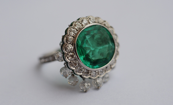 Old mine-cut emerald 7.69 karats set in platinum with hanging diamond beads, 5.48 karats 
